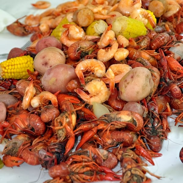 A large pile of Moruss Seafood's boiled crawfish, shrimp, potatoes, and corn on the cob.